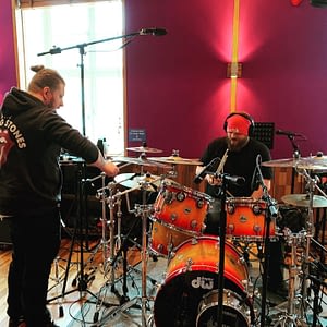 Studio team prepares the drumset in the studio for recording